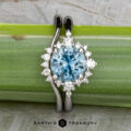 The "Veronica" ring in 14k white gold, featuring a 1.53-carat Montana sapphire and a halo of diamonds, is displayed with the matching "Veronica" band atop a green plant stalk. Logo at the bottom: Earth's Treasury.