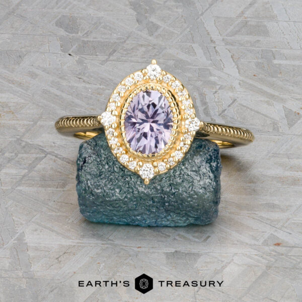 The "Marietta" ring in 18k yellow gold with 1.13-carat Montana sapphire The "Marietta" ring, crafted in 18k yellow gold with a 1.13-carat Montana sapphire and diamond accents, is displayed atop a rough blue-green stone.