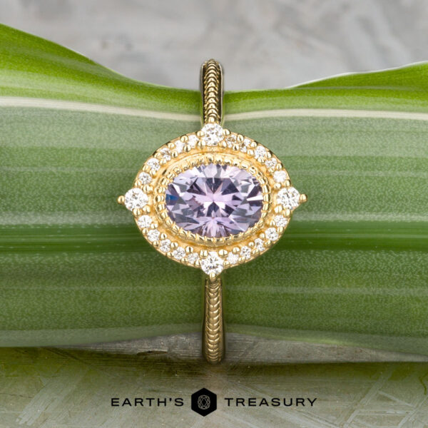 The "Marietta" ring in 18k yellow gold with 1.13-carat Montana sapphire The "Marietta" ring in 18k yellow gold features a 1.13-carat Montana sapphire, accented by small white diamonds, displayed on a green leaf with the "EARTH'S TREASURY" logo and text at the bottom.