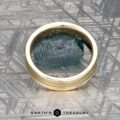 The "Silas" band in 14k yellow gold is shown with a blue textured stone on a patterned grey surface, and “Earth’s Treasury” appears at the bottom.