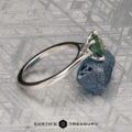 The Cathedral "Fleur" ring in platinum, featuring a 1.72-carat Montana sapphire, rests on a rough blue stone against a patterned metallic background.