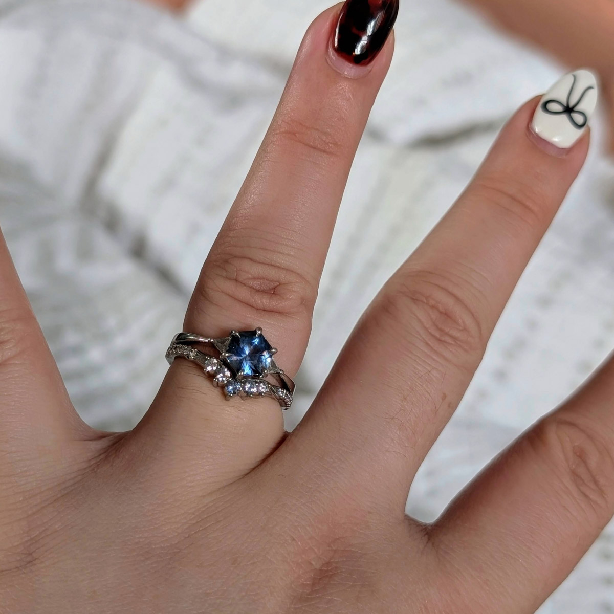 The "Melilai" ring in platinum with 1.59-carat Montana sapphire, alongside a custom wedding band in platinum
