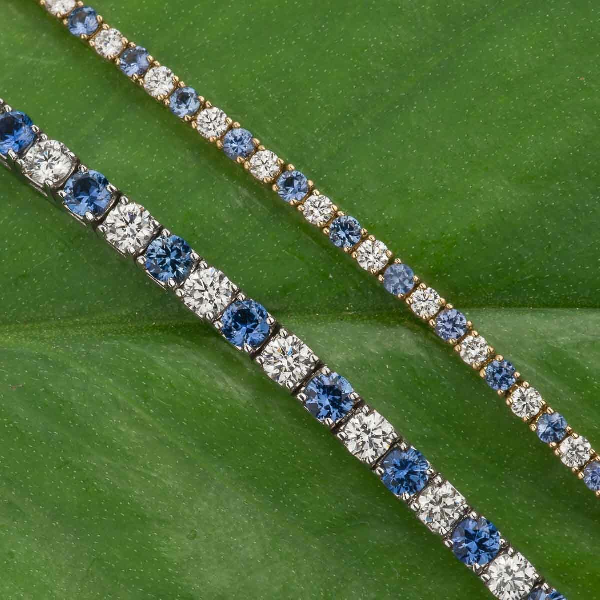 Two Bracelets, one featuring alternating blue and white gemstones and the other with all blue gemstones, are displayed against a green leaf background.