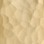 Close-up of Hammer Brush's textured beige surface featuring irregular, pebble-like patterns and a soft, matte finish.