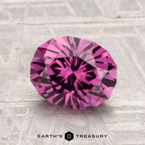 2.40-Carat Mahenge Garnet A faceted, oval-shaped 2.40-carat Mahenge Garnet is displayed on a light, textured surface with the "Earth's Treasury" logo and text at the bottom.