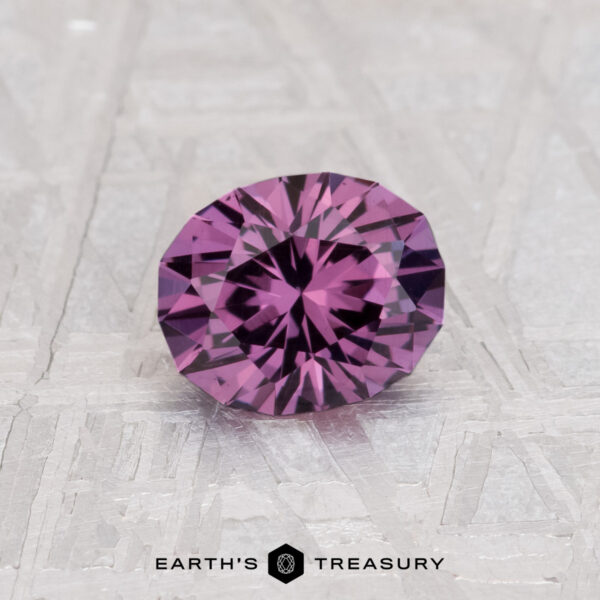 0.97-Carat Color Change Garnet A 0.97-carat color change garnet, round and faceted, is displayed on a textured light surface with "EARTH'S TREASURY" at the bottom.