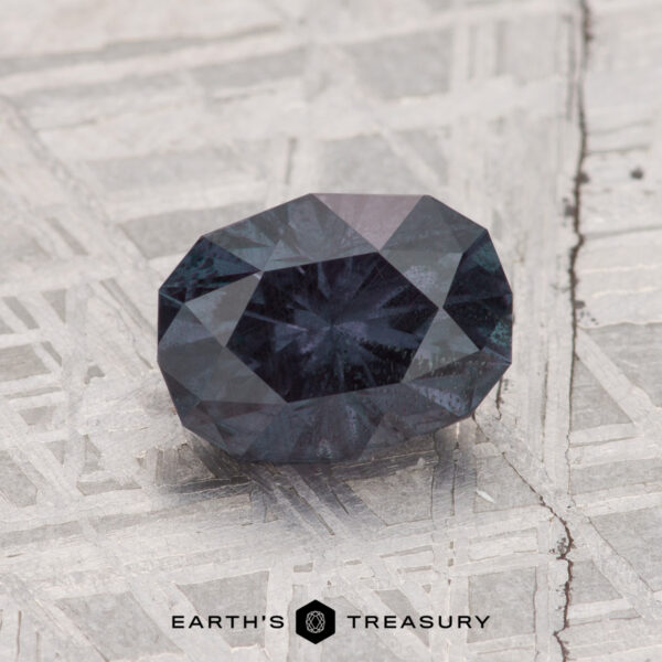 1.42-Carat Color Change Garnet A 1.42-carat color change garnet rests on a textured metallic surface, with "EARTH'S TREASURY" displayed at the bottom.