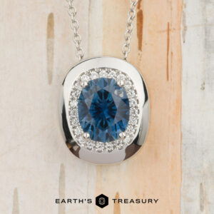 Showcasing the "Cirrus" Pendant in platinum with a 1.72-carat Montana sapphire, this elegant necklace stands out against a light, textured background. Build Your Own unique style with its stunning blue centerpiece.