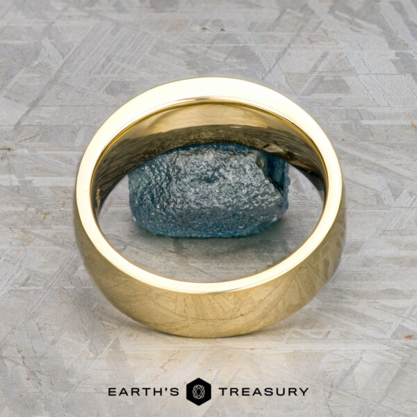 The "Matterhorn" ring in 18k royal yellow gold with 0.42-carat Montana sap A custom ring in 18k royal yellow gold with a 0.42-carat Montana sapphire stands upright on a textured gray surface, showcasing Earth's Treasury's classic Shasta-inspired design.