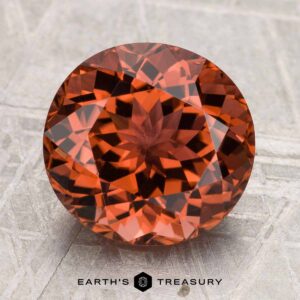 Round, faceted 4.46-carat Tourmaline gemstone displayed on a light textured surface with the text "EARTH'S TREASURY" at the bottom.