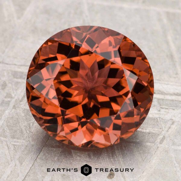 4.46-Carat Tourmaline Round, faceted 4.46-carat Tourmaline gemstone displayed on a light textured surface with the text "EARTH'S TREASURY" at the bottom.