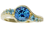 The ring-bypass is a gold ring featuring a large round blue gemstone at its center, accented by smaller blue stones set along the band.