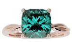 The ring-twisted-band features a cushion-cut teal gemstone set in a four-prong rose gold setting with a twisted band design.