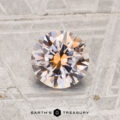 A 1.18-carat heated Montana sapphire with a peachy-pink hue is shown on a textured metallic surface, featuring "EARTH'S TREASURY" at the bottom.