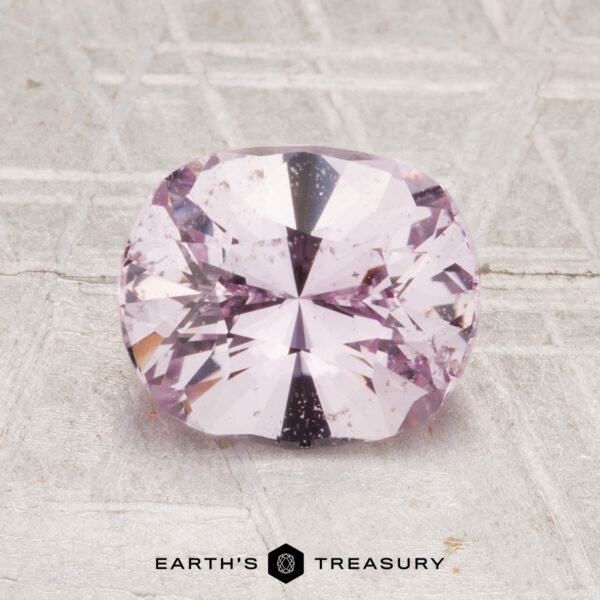 1.81-Carat Ceylon Sapphire A 1.81-carat Ceylon sapphire is displayed on a textured light gray surface, with "EARTH'S TREASURY" text below.