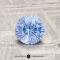 A 1.05-carat, brilliantly-cut Ceylon sapphire (heated) rests on a textured gray surface with the "EARTH'S TREASURY" logo at the bottom.