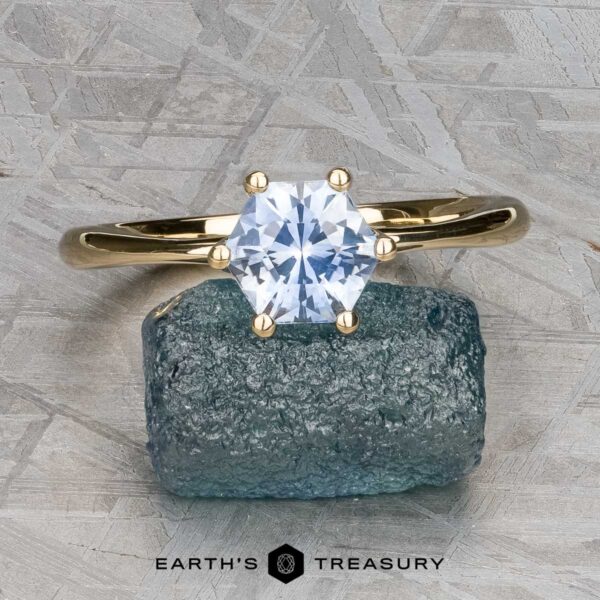 The “Vanessa” Ring in 14K yellow gold with 1.08-Carat Montana Sapphire The “Vanessa” Ring in 14K yellow gold with a 1.08-carat Montana sapphire is displayed upright on a rough blue stone, against a textured gray background. The text "EARTH'S TREASURY" appears below.