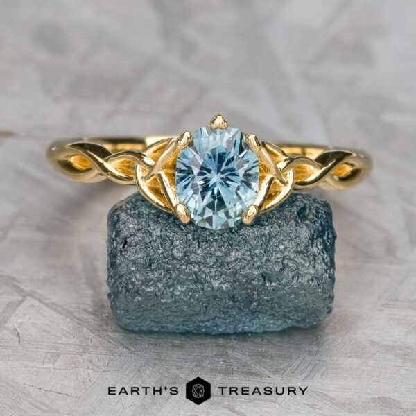 The “Siobhan” ring in 18K yellow gold with 1.02-carat Montana sapphire The “Siobhan” ring in 18K yellow gold, featuring a 1.02-carat oval Montana sapphire, is displayed on a rough blue stone with the "EARTH'S TREASURY" logo below.