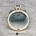 The "Clarice" ring in 14K yellow gold, featuring a 0.97-carat Montana sapphire in a prong setting, is displayed upright against a dark stone with the Earth's Treasury logo at the bottom.