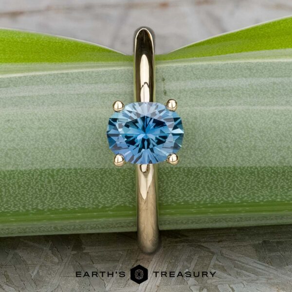 The "Clarice" ring in 14K yellow gold with 0.97-carat Montana sapphire The "Clarice" ring in 14K yellow gold with a 0.97-carat Montana sapphire rests on a green leaf.