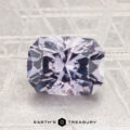 A 2.32-carat Montana sapphire with a rectangular, faceted lavender cut rests on a textured metallic surface featuring the Earth's Treasury logo at the bottom center.