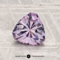 A 1.42-carat trilliant-cut light purple Montana Sapphire displayed on a textured surface with the Earth's Treasury logo at the bottom.