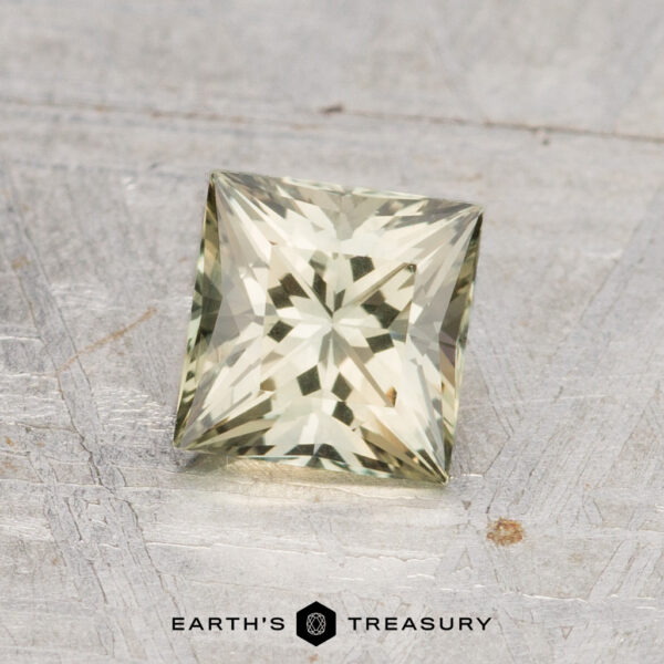 1.14-Carat Australian Sapphire (Heated) A square-cut, pale yellow 1.14-carat heated Australian sapphire with faceted surfaces is displayed on a textured metallic background, with the "Earth's Treasury" logo at the bottom.