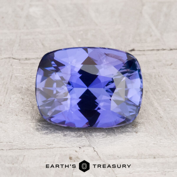 2.08-Carat Ceylon Sapphire A 2.08-carat cushion-cut Ceylon sapphire with a faceted surface, shown on a light textured background with "Earth's Treasury" beneath it.