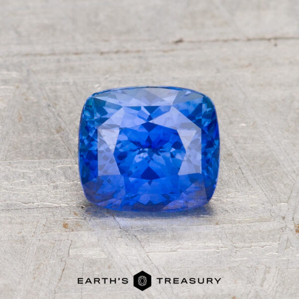 1.40-Carat Ceylon Sapphire (Heated) A 1.40-carat Ceylon Sapphire (Heated) is displayed on a light gray textured surface with "EARTH'S TREASURY" written below.
