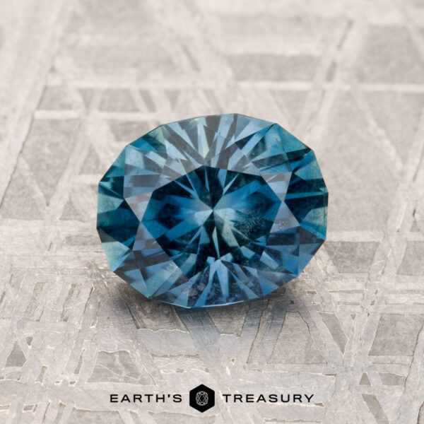 1.55-Carat Montana Sapphire A 1.55-carat Montana sapphire rests on a textured surface with the text "Earth's Treasury" below it.