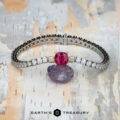 The "Araceli" Bracelet in 14K white and yellow gold with a 2.96-carat spinel is displayed on a rough purple stone against a light patterned background. The bottom features the logo text "Earth's Treasury.