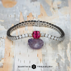The "Araceli" Bracelet in 14K white and yellow gold with a 2.96-carat spinel is displayed on a rough purple stone against a light patterned background. The bottom features the logo text "Earth's Treasury.