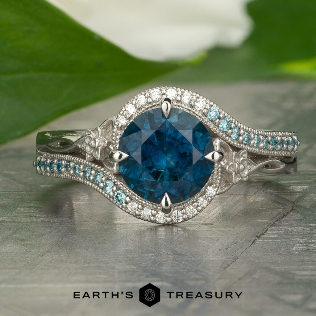 The "Stacked from 22 images. Method=B (R=14,S=2)" ring showcases a large round blue gemstone at its center, surrounded by small white and blue stones with floral accents, and the "Earth's Treasury" logo beneath.