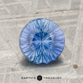 A round, faceted 1.89-carat Ceylon Sapphire gemstone is displayed on a textured gray surface with the text "Earth’s Treasury" at the bottom.
