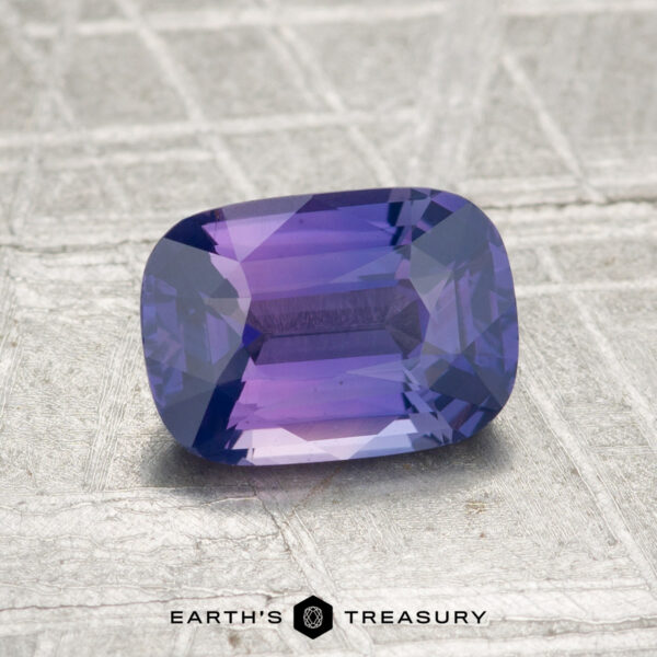 1.51-Carat Ceylon Sapphire A 1.51-carat Ceylon sapphire, cushion-cut and purple, is shown on a textured silver-gray surface with the text "EARTH'S TREASURY" below.