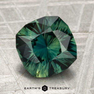 A 3.24-carat faceted green sapphire with intricate internal patterns is displayed on a textured surface, with the "Earth's Treasury" logo at the bottom.