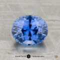 A 2.29-carat heated Ceylon sapphire with an oval cut is displayed on a textured surface, with "EARTH'S TREASURY" featured below.