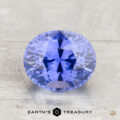 A faceted, oval-cut lavender-blue 2.29-carat heated Ceylon sapphire is displayed on a light textured surface with the text “EARTH’S TREASURY” beneath.