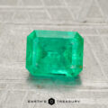 A 1.42-carat emerald gemstone in a rectangular cut is displayed on a textured surface, with "Earth's Treasury" written below.