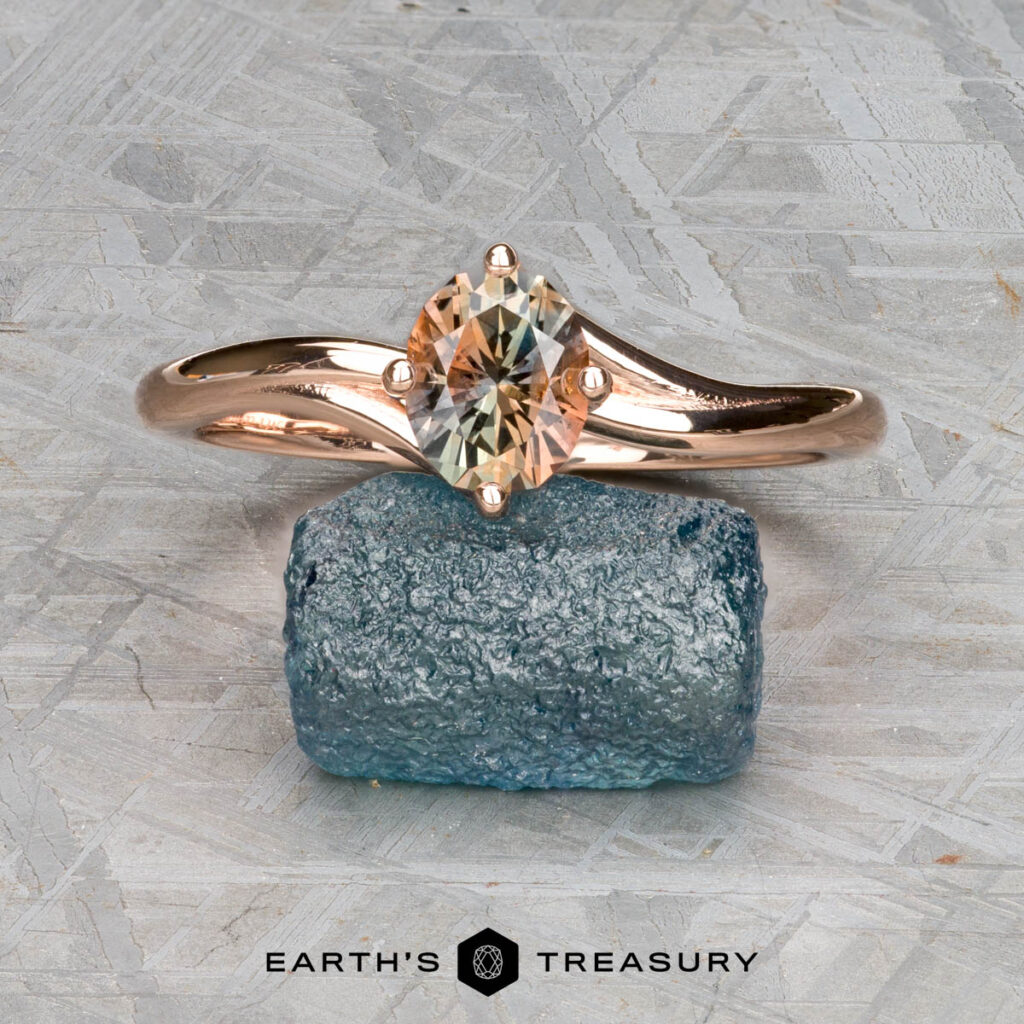 The "Moore, Andrew and OBrian, Kelly 1" ring is shown upright atop a rough blue stone, with the text "Earth's Treasury" displayed at the bottom.