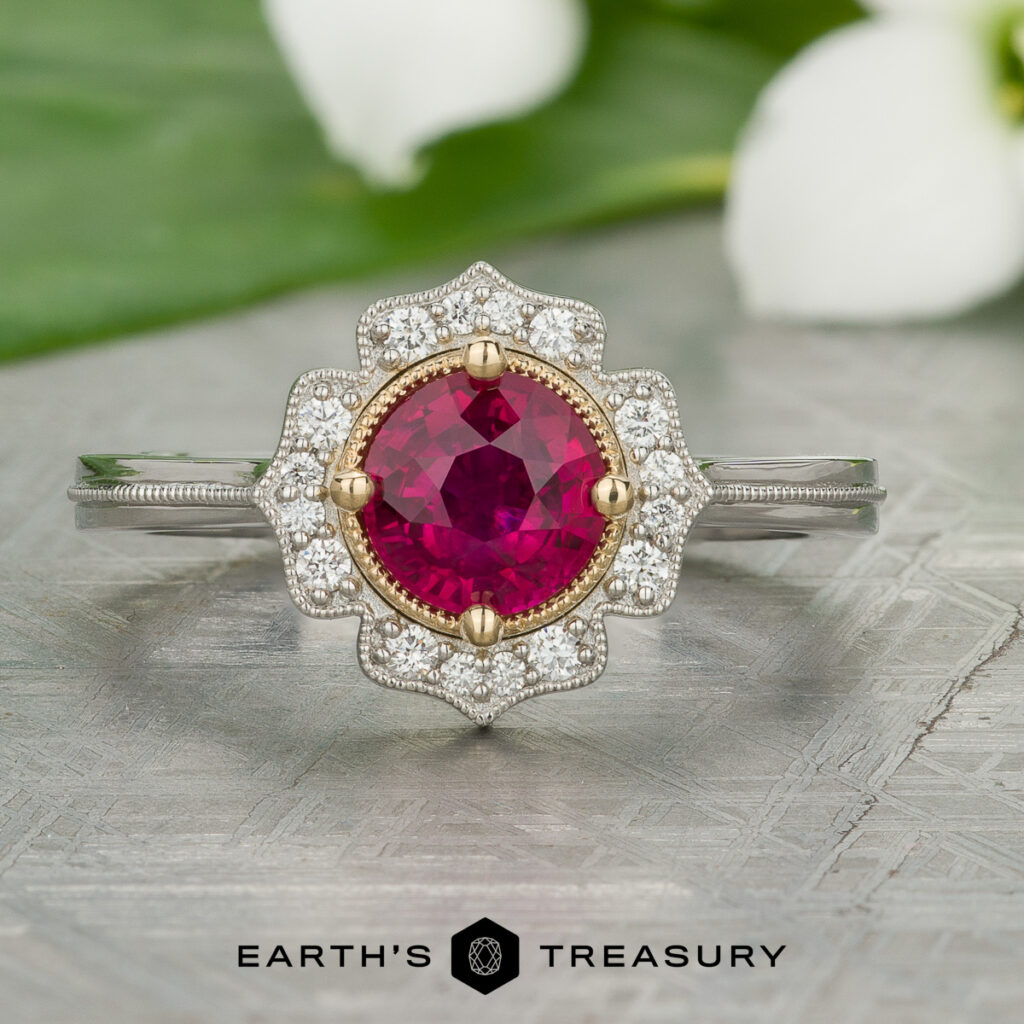 Stacked from 19 images using Method=B (R=7, S=2), a silver ring features a round red gemstone center and small white diamonds in a floral pattern, displayed on a textured surface.