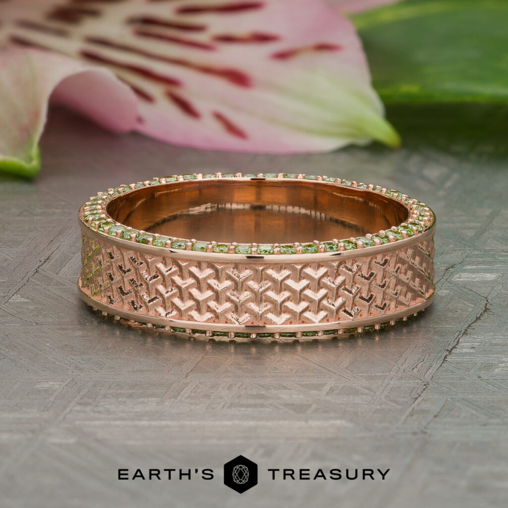 The "Stacked from 31 images. Method=B (R=7,S=2)" is a rose gold ring with a textured geometric pattern and a border of small green stones, shown on a decorative surface with floral and leaf accents in the background.