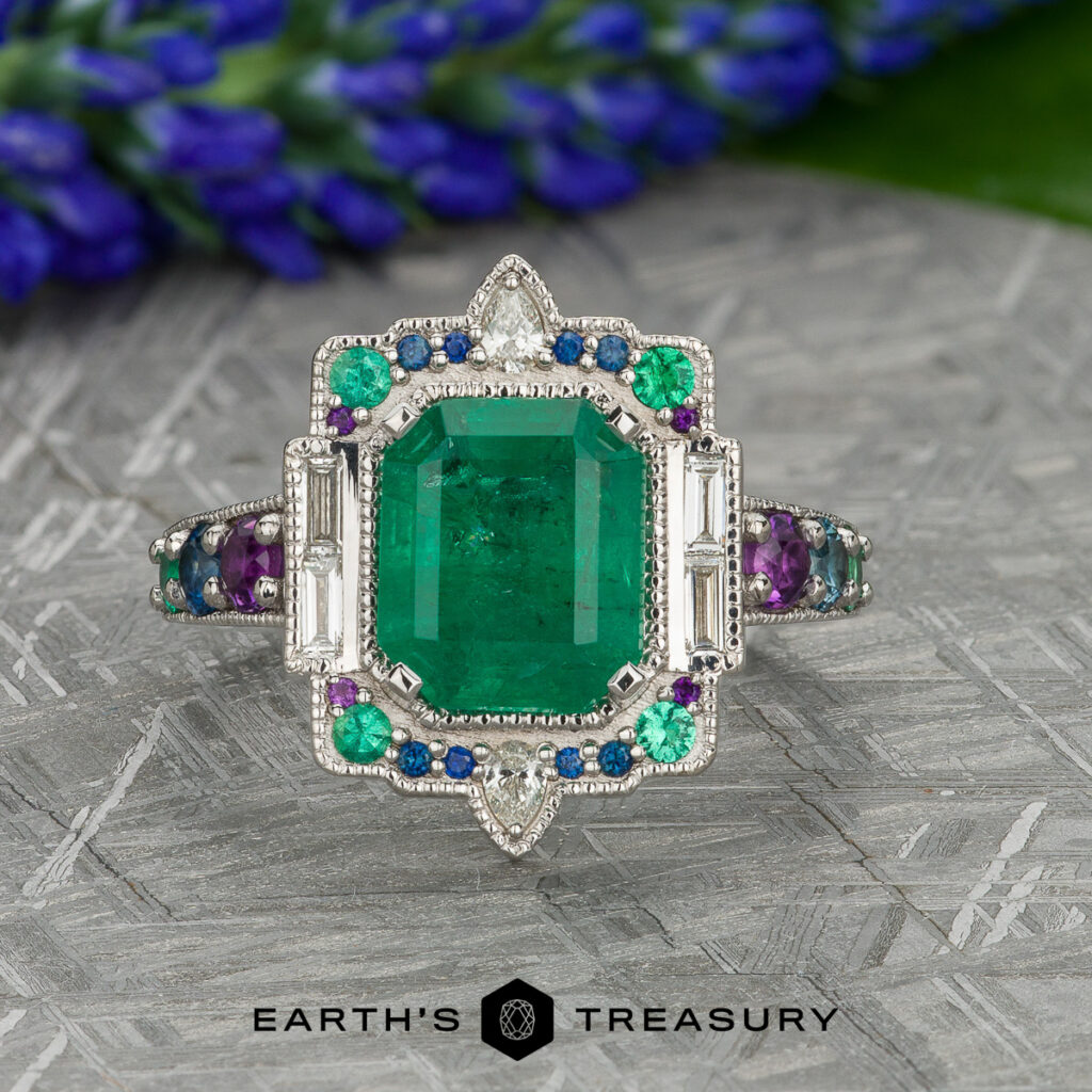 The "Stacked from 24 images. Method=B (R=7,S=2)" ring features a rectangular emerald with diamond, blue, and purple gemstones, set in silver and photographed on textured gray with purple flowers in the background.