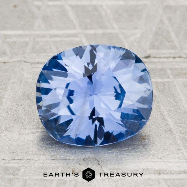 2.88-Carat Ceylon Sapphire A 2.88-carat Ceylon sapphire with a cushion cut is shown on a textured gray surface, featuring the "Earth's Treasury" text below.