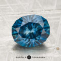 2.89-carat heated Montana sapphire, faceted oval blue gemstone shown on a textured surface with "Earth’s Treasury" at the bottom.