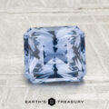 A 2.32-carat Ceylon sapphire, square-cut with intricate facets, rests on a textured gray surface. The "EARTH'S TREASURY" logo and text are featured at the bottom.