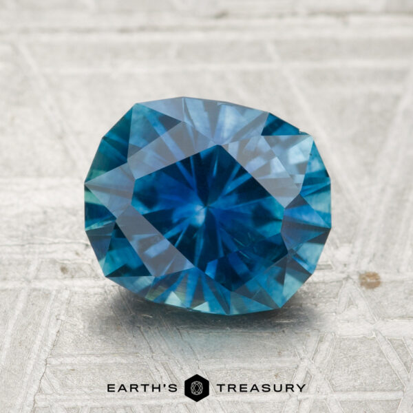 2.35-Carat Montana Sapphire (Heated) A 2.35-carat heated Montana sapphire is displayed on a textured surface with the Earth's Treasury logo and name at the bottom.