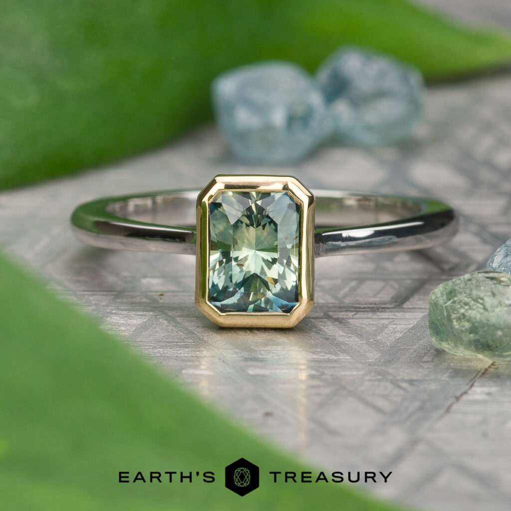 The "Kretzschmar, Matthew [custom gallery]" ring features a rectangular green gemstone set in gold with a silver band, adorned with blue-green stones and leaves. The "Earth's Treasury" logo appears at the bottom of the display.