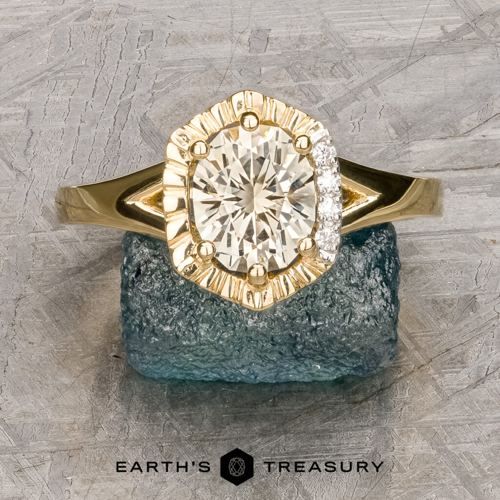 The "Pickering, Robert (Bob) and Sarah [custom gallery]" gold ring with a round central diamond and side stones rests on a rough blue stone, featuring the "Earth's Treasury" logo beneath.
