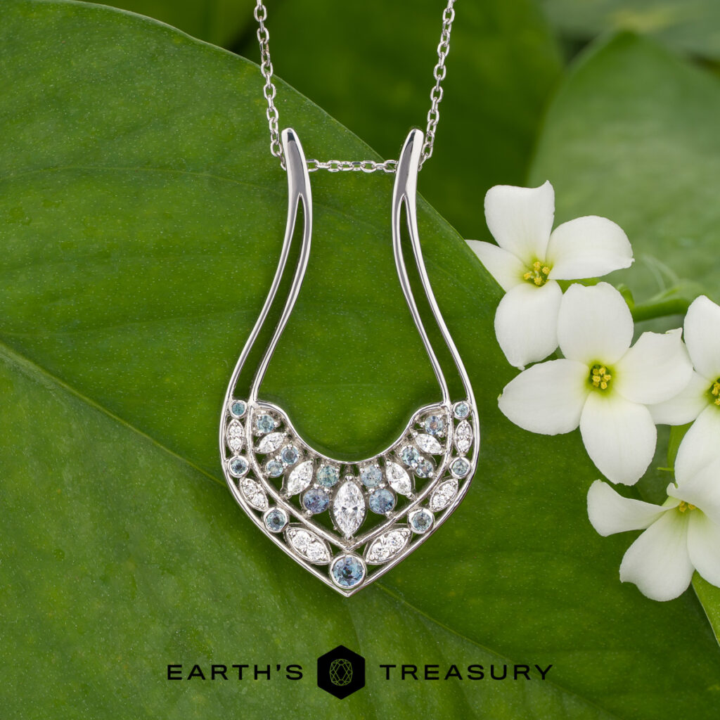 The Nabavi, Ali and Baran, Heather 15 custom gallery features a silver necklace with multiple diamonds on a large green leaf beside white flowers, with the Earth's Treasury logo below.